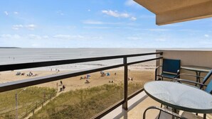 A balcony with a view of a beach, a table, and chairs. - Seawatch Oceanview Unit 502 (Old Orchard Beach)