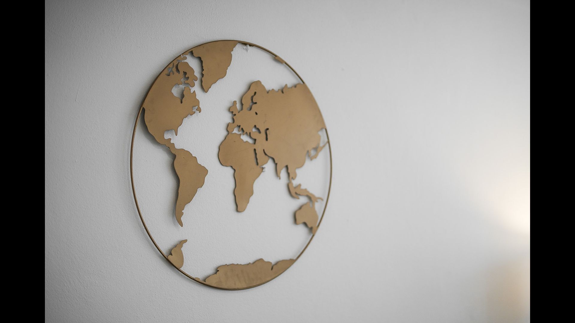 A circular wall decoration with a cut-out world map.