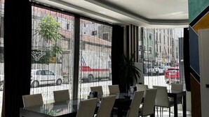 Un comedor con mesa de vidrio, sillas y ventilador de techo.