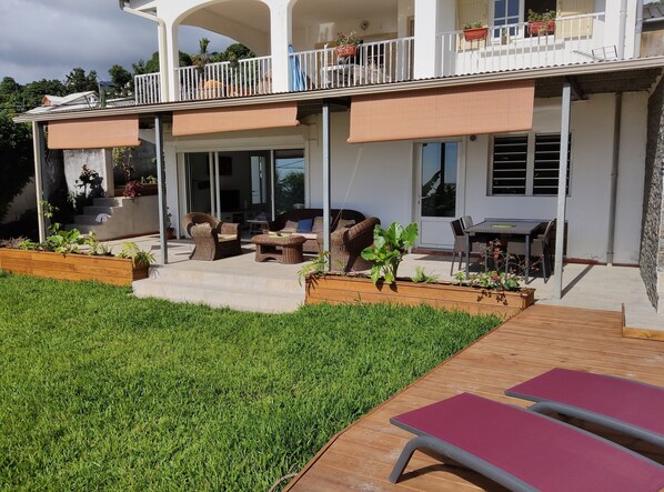A modern house with a covered patio, outdoor furniture, and a well-maintained garden. - seasonal rental for 4 people max in large independent garden level (Saint Paul)