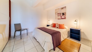 A bedroom with a bed, a chair, a nightstand, and a wall art piece. - seasonal rental for 4 people max in large independent garden level (Saint Paul)