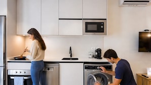 Een moderne keuken met een magnetron, vaatwasser en oven.