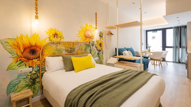 Een moderne hotelkamer met een groot bed, een zithoek en uitzicht op de stad.