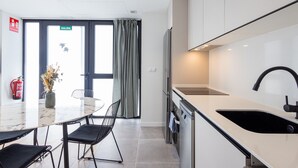 A modern kitchen with a large island, stainless steel appliances, and a black faucet. - Turia Park Loft IV | 4 Guests | AC and WiFi | Near ZOO (Valencia)