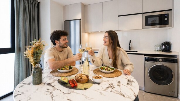 A modern kitchen with a dining table, a refrigerator, a microwave, and a washing machine. - Turia Park Loft IV | 4 Guests | AC and WiFi | Near ZOO (Valencia)