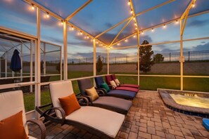 Une terrasse extérieure avec des chaises longues et un jacuzzi.