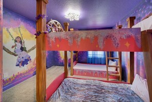 A bedroom with a bunk bed, a mural on the wall, and a ceiling light fixture.