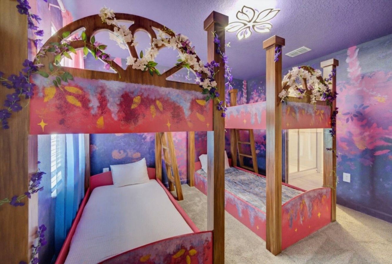 A bedroom with a bunk bed, a canopy bed, and a decorative archway.