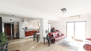A modern apartment with a kitchen, dining area, and living room.