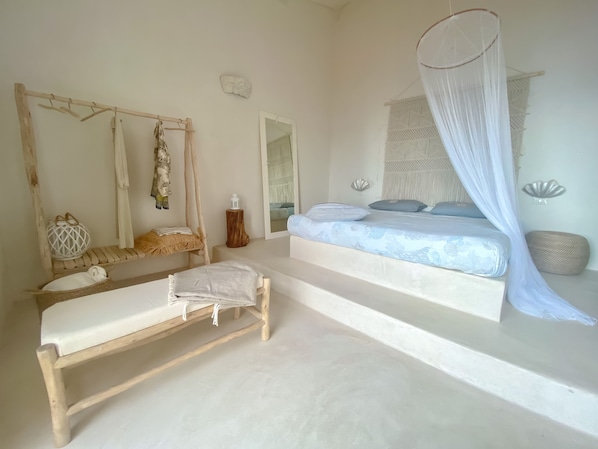 A bedroom with a bed, a daybed, a hanging chair, and a canopy bed.