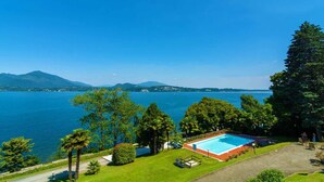 A pool area with a view of a lake and mountains. - Blue Lake apartment with pool and lake view (Stresa)