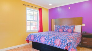 A bedroom with a bed, a window with a red curtain, and a purple wall. - Economy Inn By OYO Lockport near Houma (Lockport)