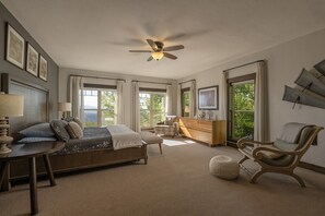 A bedroom with a bed, bedside tables, a chair, a dresser, and a ceiling fan.