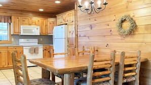 Un interior de madera con una mesa de comedor y sillas, un refrigerador y un microondas.