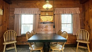 Una sala da pranzo in legno con un tavolo rettangolare e sei sedie di legno.