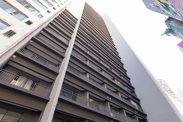 A high-rise building with multiple balconies and a modern architectural design.