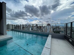 A rooftop pool with a city view, surrounded by high-rise buildings.