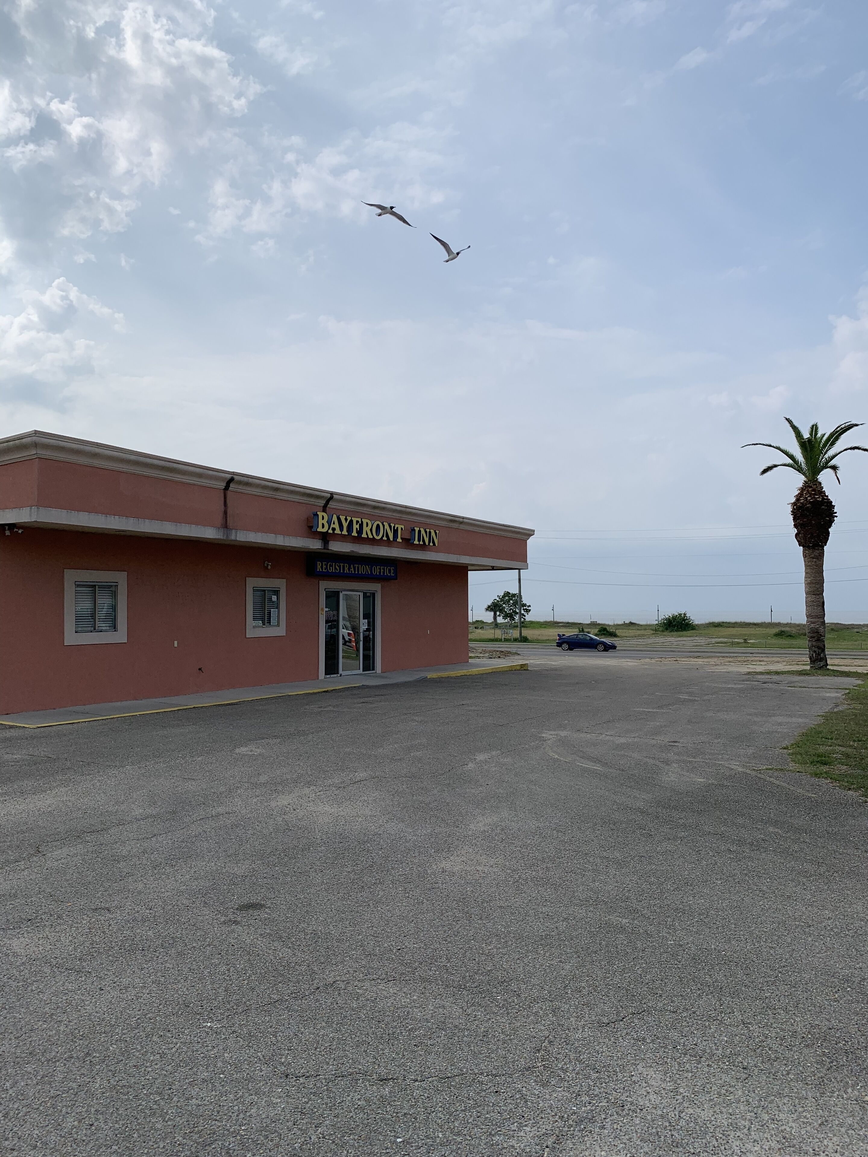 A building with a sign reading "Bayfront Inn" and a "Registration Office" sign.