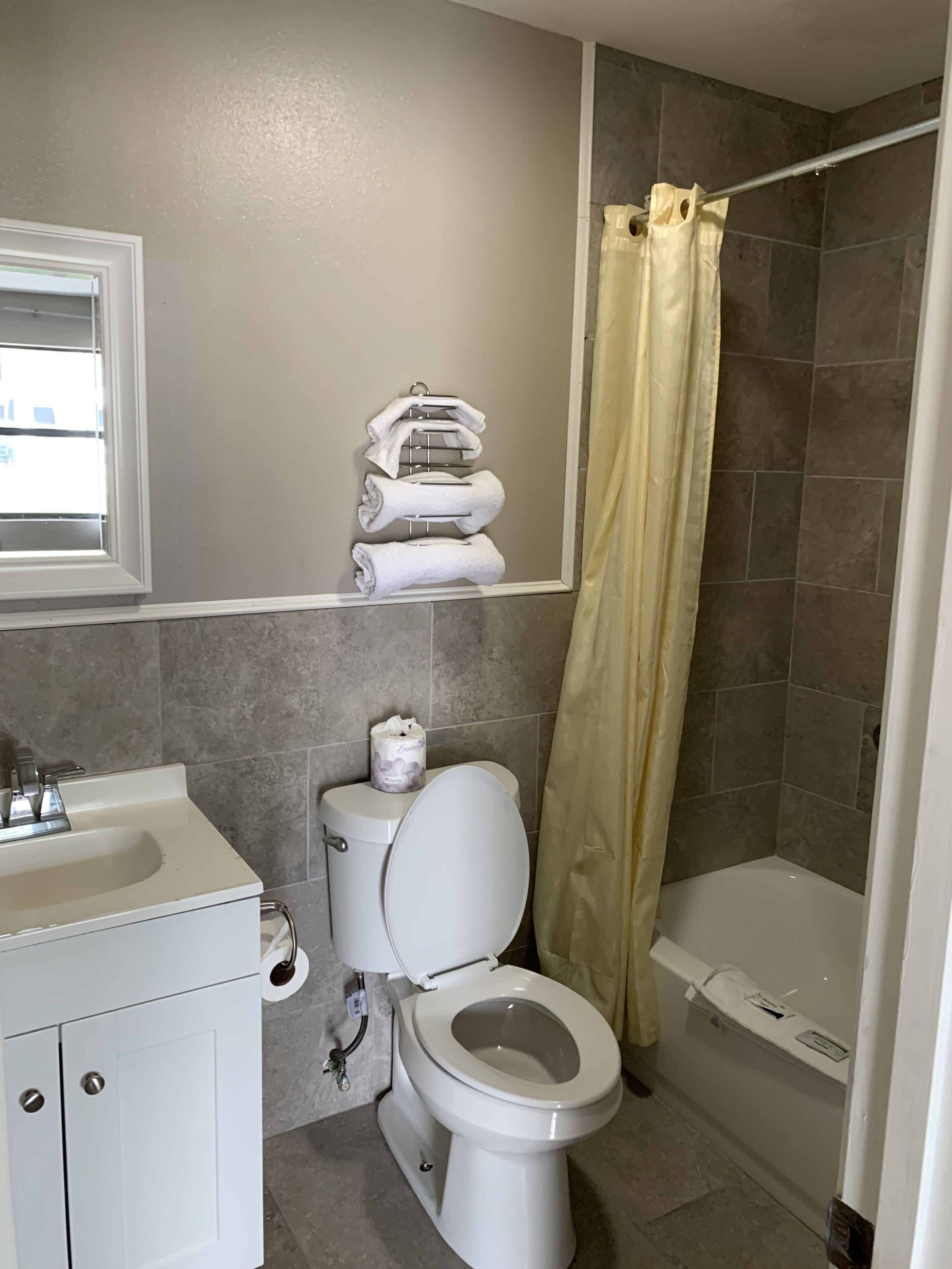 A bathroom with a toilet, sink, and shower.