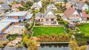 Un barrio residencial con casas, un río y un césped bien cuidado.