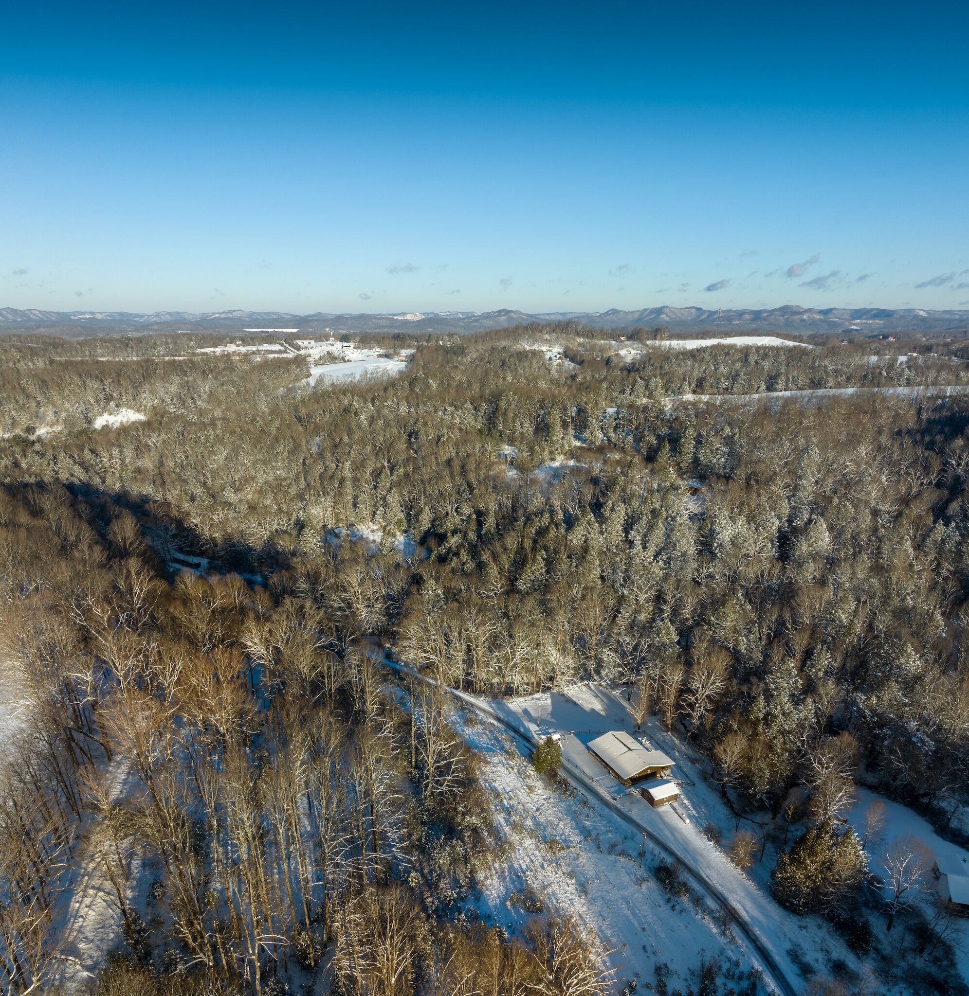 Un paysage enneigé avec un bâtiment situé sur une colline.