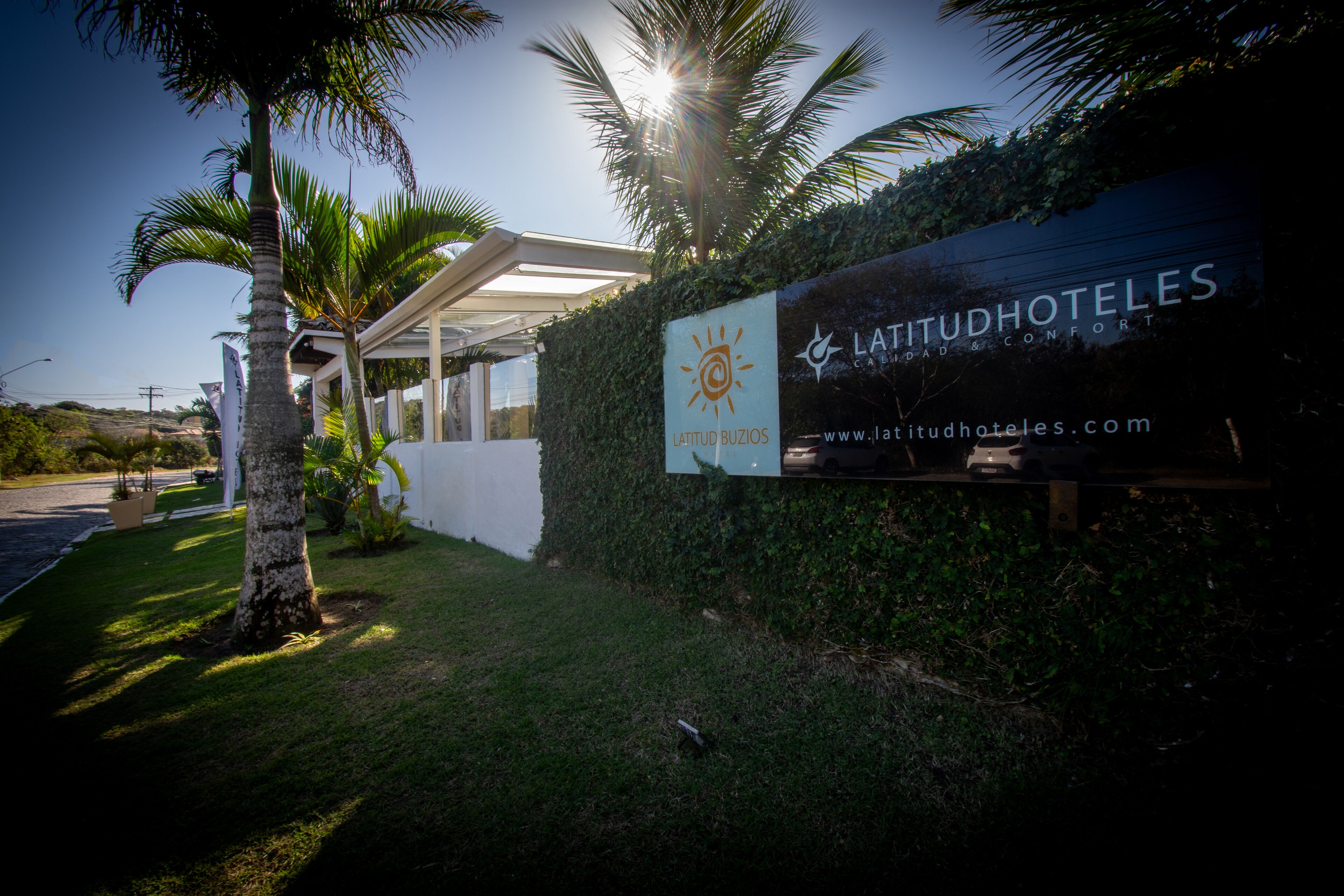 Señal de 'Latitud Hoteles' con un logo de sol, indicando un hotel de temática tropical.