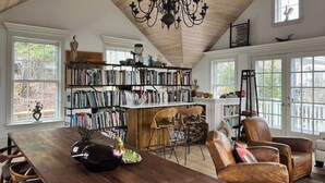 A spacious room with a high ceiling, a large wooden table, a bookshelf, and leather chairs. - Prime cliff road location, Walk to town,  great light, duplex home,  (Nantucket)