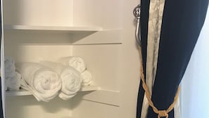 A hotel room with a built-in closet containing neatly folded towels on shelves. - Romantic Coastal Private Room is located 10 minutes from all sightseeing places  (Oxnard)
