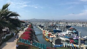 A marina with boats docked, a clear sky, and a sign reading "VENTURA HARBOUR". - Romantic Coastal Private Room is located 10 minutes from all sightseeing places  (Oxnard)