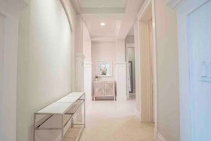 A hallway with a white console table, a mirror, and a cabinet. - 505 Sunset Key Estate | Luxury Courtyard Pool Home (Naples)