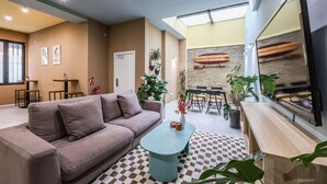 Uma sala de estar moderna com sofá, mesa de centro e área de jantar com cadeiras e mesa.