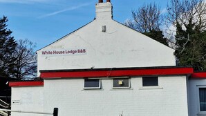 A white building with a red roof and chimney, labeled "White House Lodge B&B." - White House Lodge B&B (Cambridge)