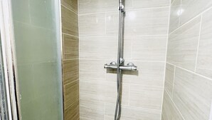 A shower with a handheld showerhead and a fixed wall-mounted faucet. - White House Lodge B&B (Cambridge)