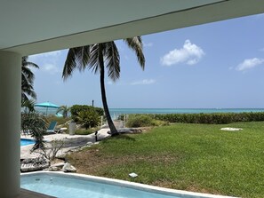 A pool area with a view of the ocean and a clear sky.