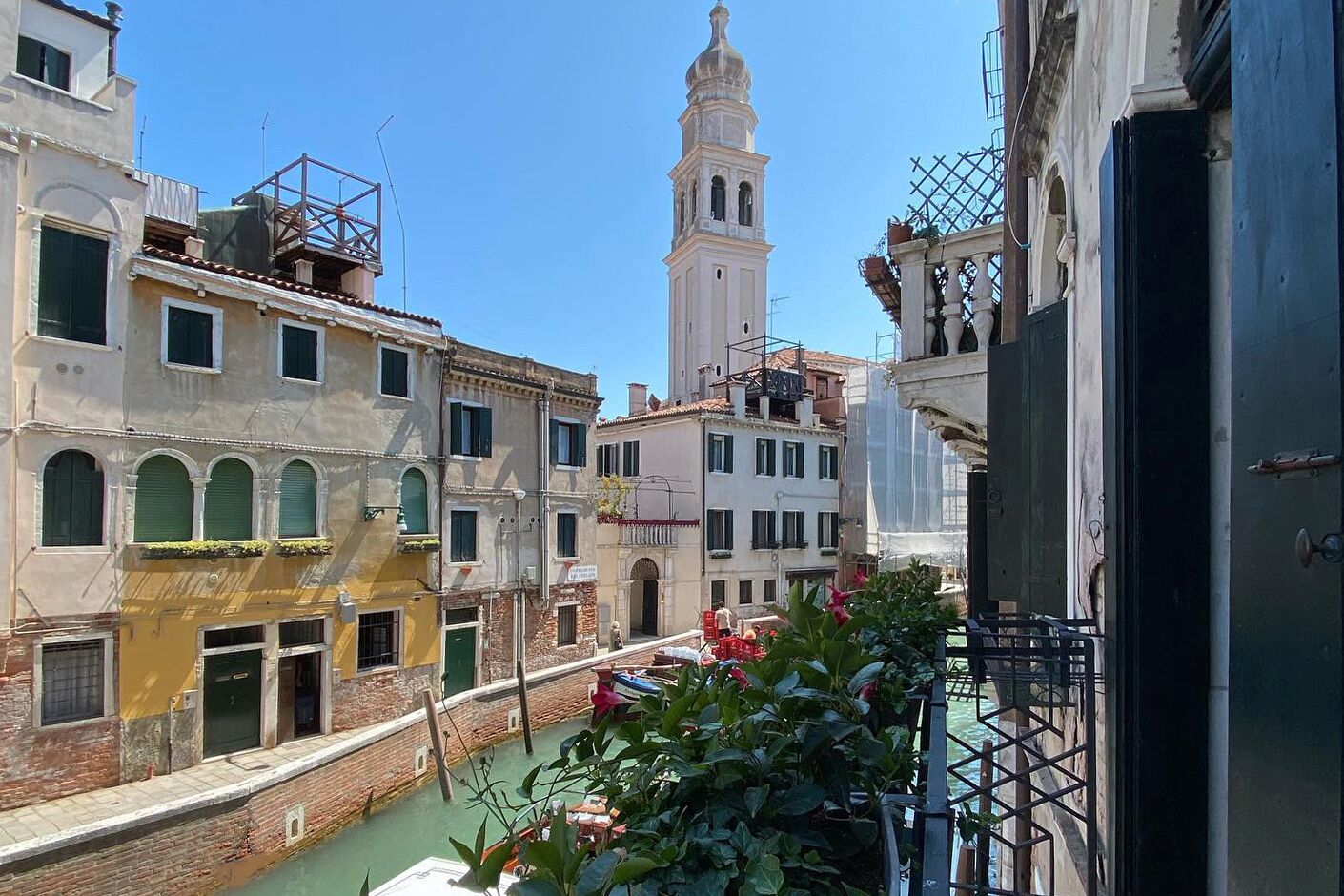 Vista de um canal com edifícios em ambas as margens, incluindo uma torre imponente.