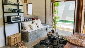 A modern living room with a sofa, a coffee table, a gas stove, and a bookshelf.