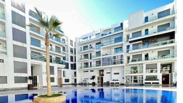 Un bâtiment moderne doté d’une piscine centrale entourée de balcons.