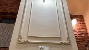 Une porte blanche ornée d’un panneau décoratif et dotée d’un interrupteur.
