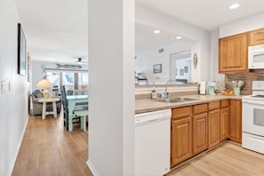 Una cocina moderna con armarios de madera, microondas empotrado y lavavajillas.