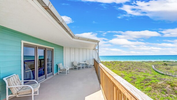A balcony with a view of the ocean, a wooden deck, and a row of chairs. - La Mirage Condo 329 Beachfront Condominiums Resort with Private Boardwalk to Beach (Port Aransas)