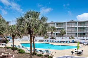 Relax by the pool surrounded by lounge chairs and umbrellas.