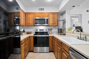 Enjoy cooking in this well-equipped kitchen with a range hood, microwave, double oven, and ample storage.