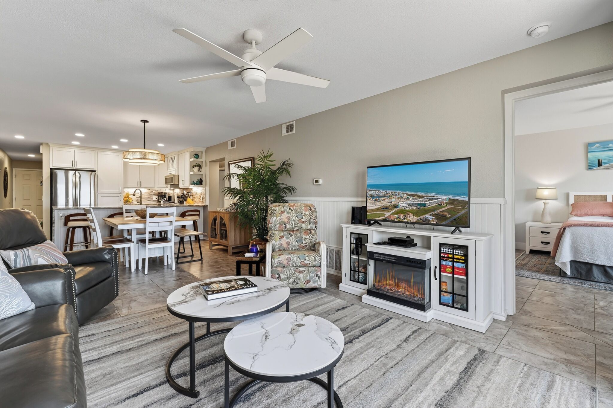 A modern living room with a fireplace, a television, and a dining area.
