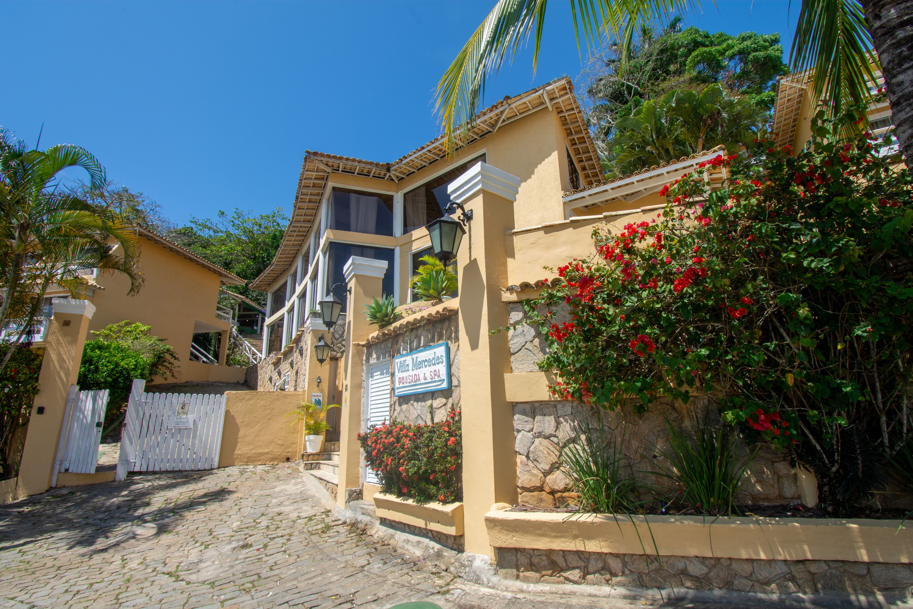 A villa with a stone facade, a tiled roof, and a sign indicating it is a villa and spa.