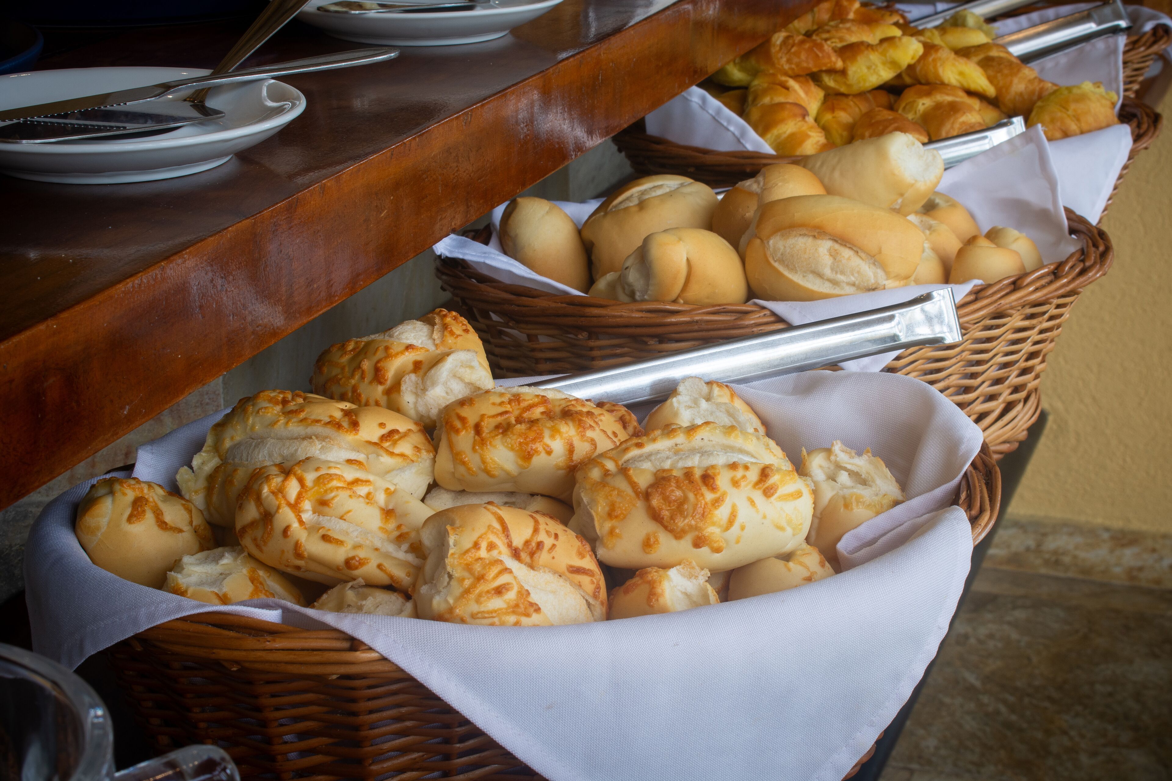 Un buffet proposant une variété de produits de boulangerie, notamment des petits pains et des viennoiseries.