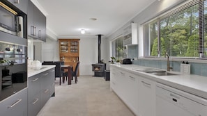 Enjoy meals in the kitchen with a stove and ample counter space, plus a dining area with a table and chairs.