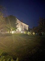 Una casa grande e histórica con un césped bien cuidado y una valla de piquetes.
