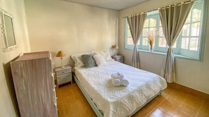 A bedroom with a bed, nightstands, a dresser, and a window with curtains. - El Nogal, Acogedora Cabaña con Jardín y Cochera (Vistalba Luján de Cuyo)