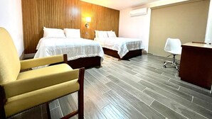 A hotel room with two beds, a desk, a chair, and a wooden accent wall. - NEO BUSINESS HOTEL (Culiacán)
