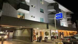 A modern hotel with a flat facade, multiple balconies, and a visible restaurant sign. - NEO BUSINESS HOTEL (Culiacán)